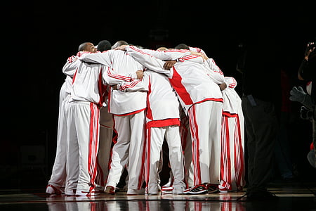 men huddled together before a game inside stadium thumbnail
