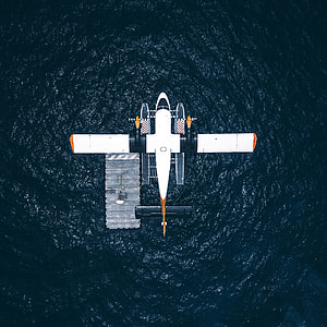 white, orange, and black boat airplane above body of water thumbnail