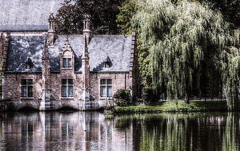 brown and gray concrete house beside body of water thumbnail