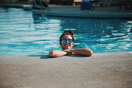 woman wearing blue sunglasses standing in pool thumbnail