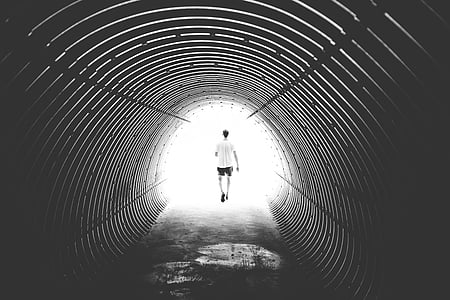 man wearing white shirt and black shorts walking in tunnel thumbnail