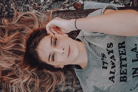 woman lying on brown rag while holding her face thumbnail
