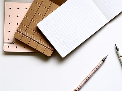 white and blue ruled paper near pink and white ballpoint pens thumbnail