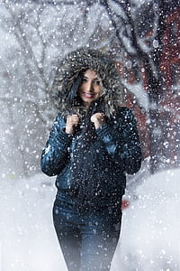 woman wearing black parka jacket standing outdoors during snowy day thumbnail