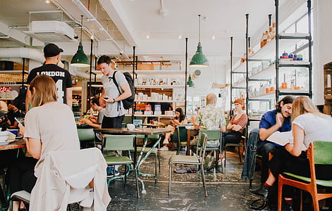 people sitting on arranged chairs and tables inside room thumbnail