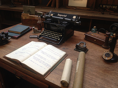 Imperial typewriter near book and candle stick telephone on desk thumbnail