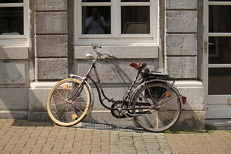 black and gray commuter bike parked next to concrete wall thumbnail