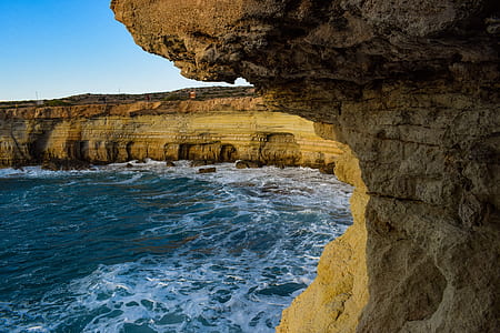 brown rock formation near body of water thumbnail