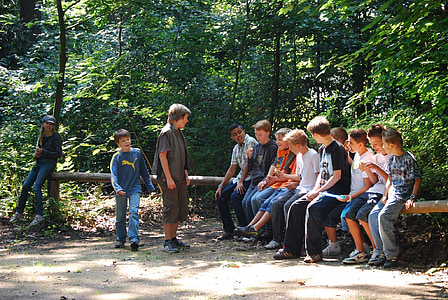 photo of group of people sitting on tree log thumbnail