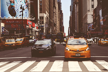 two brown and black vehicle on roadway between buildings thumbnail