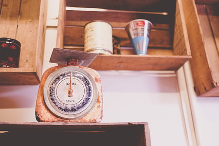 brown and blue kitchen scale on top of brown wooden shelf thumbnail
