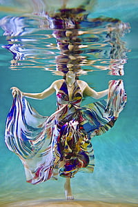 photography of woman in multicolored dress under water thumbnail
