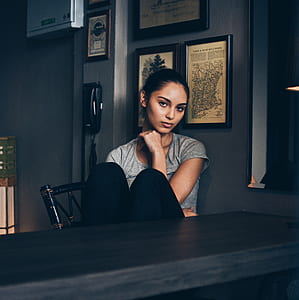 woman sitting on beside black wooden table thumbnail