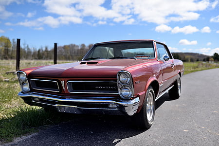 classic red Pontiac GTO coupe parked on roadside at daytime thumbnail