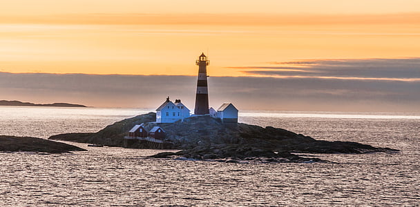 photography of brown lighthouse near island at daytime thumbnail