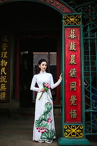 woman standing while holding pink flowers bouwuet thumbnail