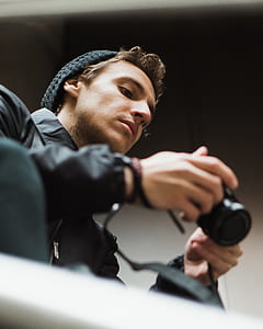 man in black jacket holding a camera thumbnail