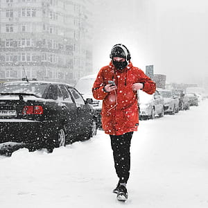 man holding gray Android smartphone while walking on snow field thumbnail