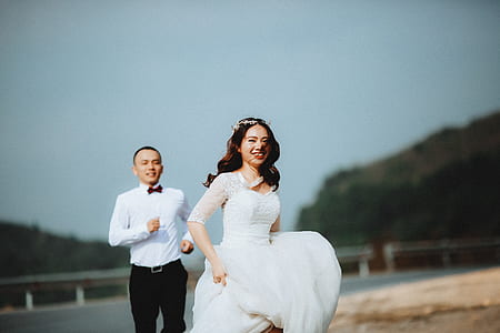 man chasing woman near sea shore during daytime thumbnail