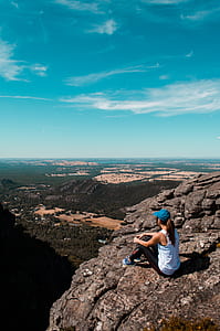 woman sitting on rock mountain cliff thumbnail