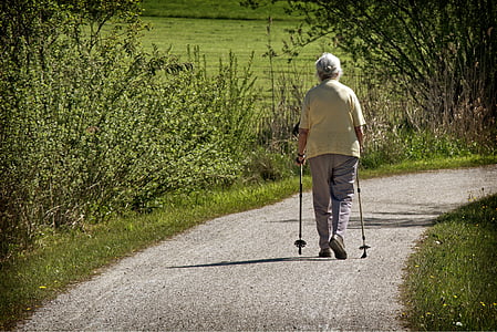 woman wearing beige shirt walking down a street thumbnail