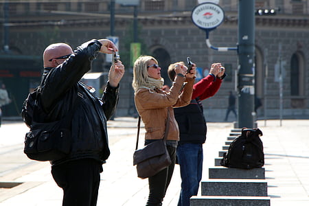 three people holding cameras standing near post thumbnail