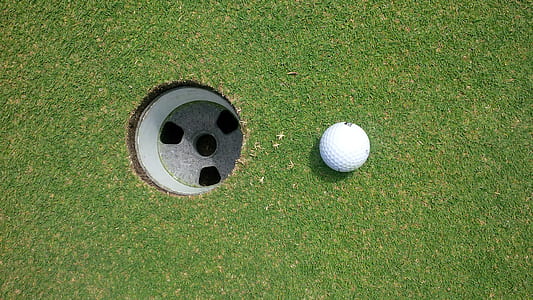 white golf ball near hole thumbnail