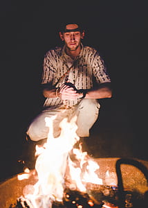 man sitting in front of bonfire thumbnail
