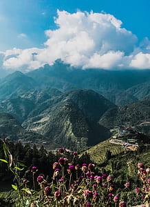 aerial view photography of village near mountain range under cumulus clouds thumbnail