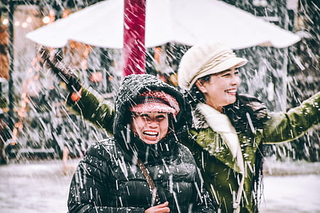 two woman smiling wearing snowsuit during snowfall thumbnail