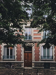 bicycle parked near white and orange concrete 3-storey building thumbnail