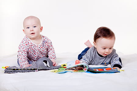 two baby crouching on white surface thumbnail