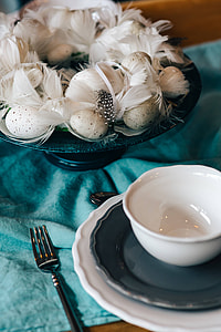 Fancy restaurant dinner table decorated with quail eggs and feathers thumbnail