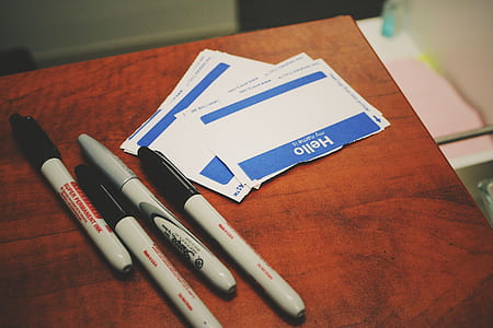 four gray pens on brown table thumbnail