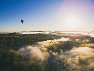 hot air balloon flying over green trees during daytime thumbnail