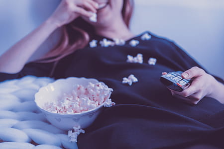 Happy woman watching TV and eats popcorn at night thumbnail
