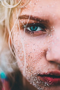 selective focus photography of woman with sand on her face thumbnail