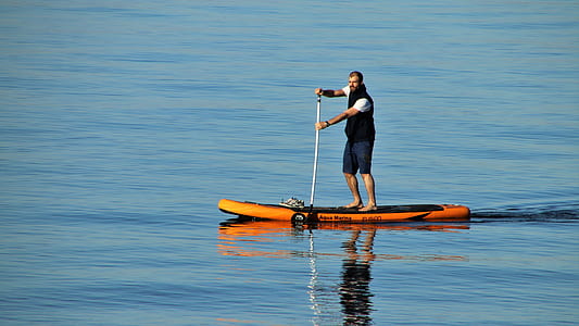 man riding on orange kayak thumbnail