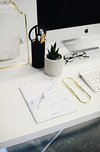 white and black book above white wooden table thumbnail
