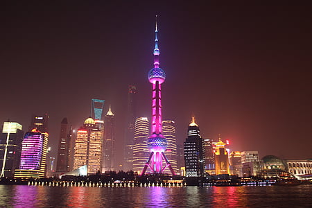 lighted city buildings near body of water thumbnail