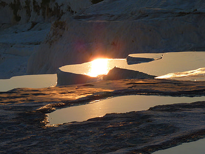 silhoutte photography of body of water and land formations during golden hour thumbnail