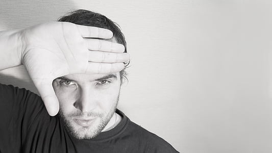 grayscale photo of man in crew-neck top raising his right hand thumbnail