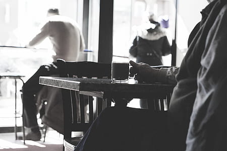 grayscale photography of person holding mug of coffee thumbnail