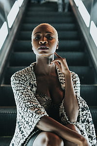 woman in black and white cardigan sitting on escalator looking fierce thumbnail