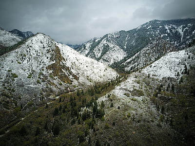mountains covered with snow under white cloudy sky thumbnail