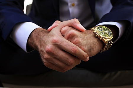 person wearing round gold-colored skeleton watch with gold-colored band thumbnail