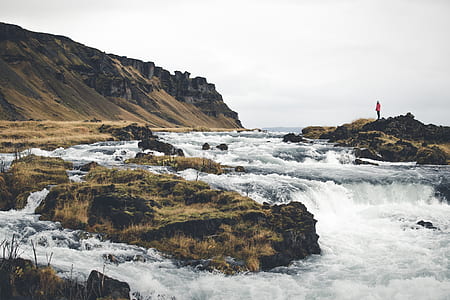 river near mountain under white clouds during daytime thumbnail