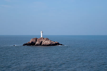 white lighthouse on islet thumbnail
