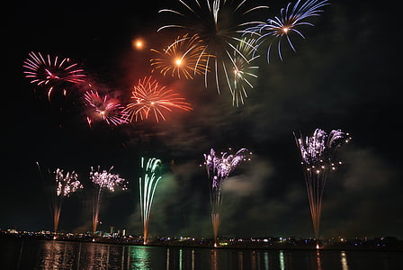 city lights near body of water with fireworks display thumbnail