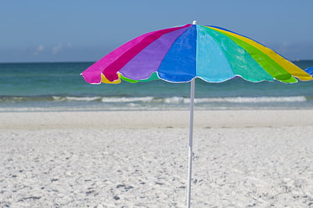 rainbow-colored umbrella on seashore thumbnail